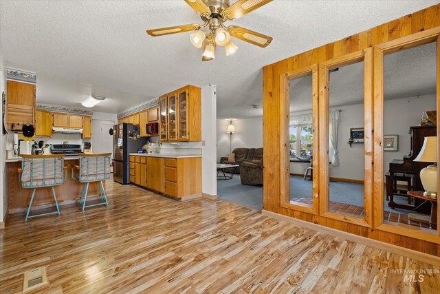 4667 S Shawnee Way, Boise, ID 83709 - kitchen featuring under cabinet range hood, freestanding refrigerator, electric stove, a peninsula, and light wood finished floors