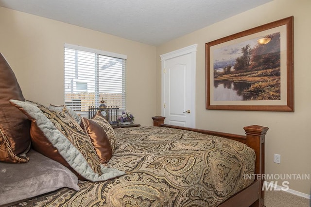 bedroom featuring baseboards and carpet