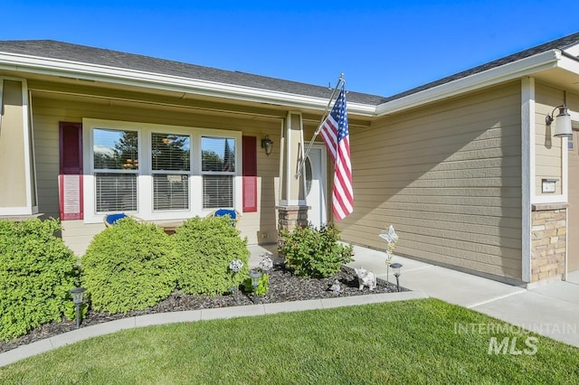 entrance to property featuring a lawn
