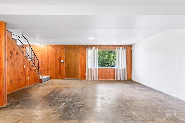 1015 24th St, Lewiston, ID 83501 - unfurnished living room with concrete flooring, stairway, and wooden walls