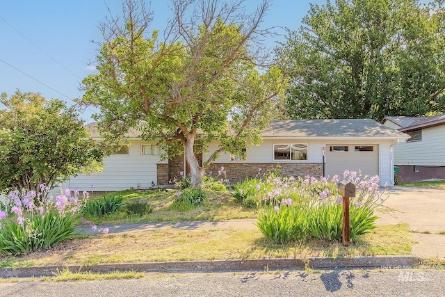 1015 24th St, Lewiston, ID 83501 - view of front facade with a garage, driveway, and stone siding