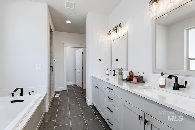 3389 E Englehart Dr, Meridian, ID 83642 - full bathroom featuring double vanity, a bath, tile patterned flooring, a shower stall, and recessed lighting