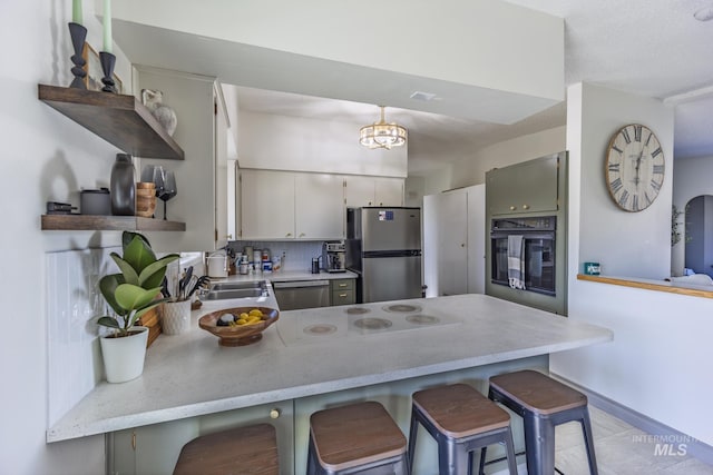 kitchen with a breakfast bar, a peninsula, open shelves, appliances with stainless steel finishes, and tasteful backsplash