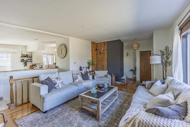 living room featuring plenty of natural light, a textured ceiling, and wood finished floors