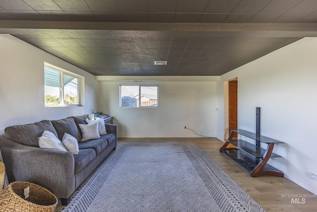 living room with visible vents, baseboards, and wood finished floors