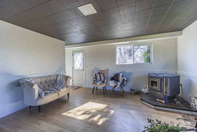 living area with a wood stove and wood finished floors