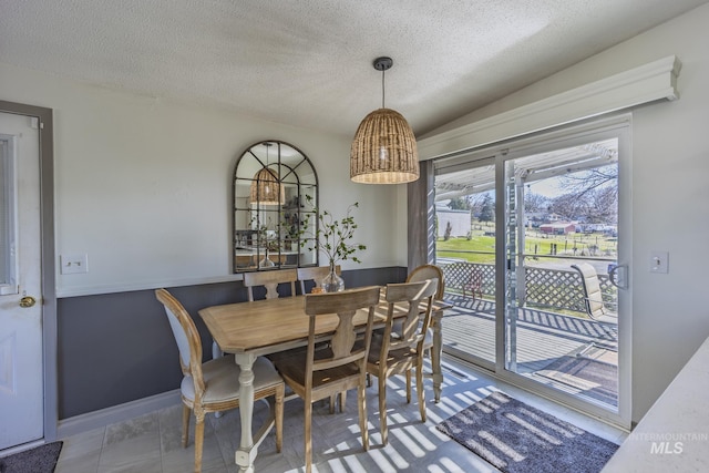 dining room with baseboards and a textured ceiling