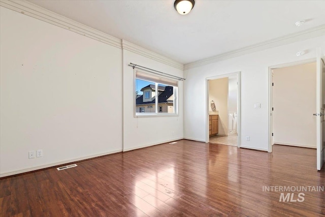 empty room with crown molding and hardwood / wood-style flooring