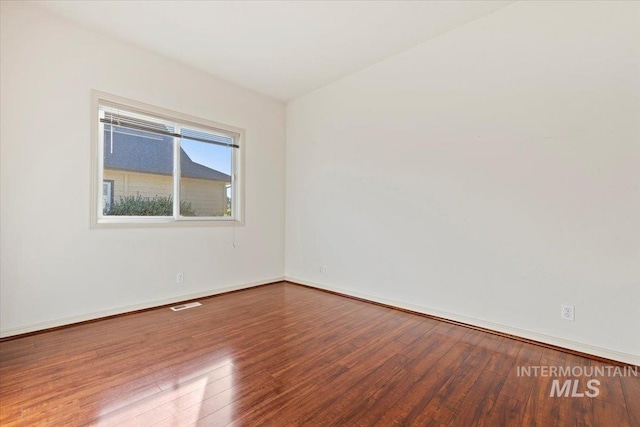 spare room with hardwood / wood-style flooring