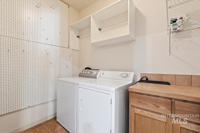 clothes washing area featuring washer and clothes dryer and light tile patterned floors