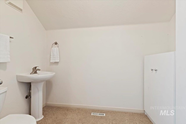 bathroom featuring a textured ceiling and toilet