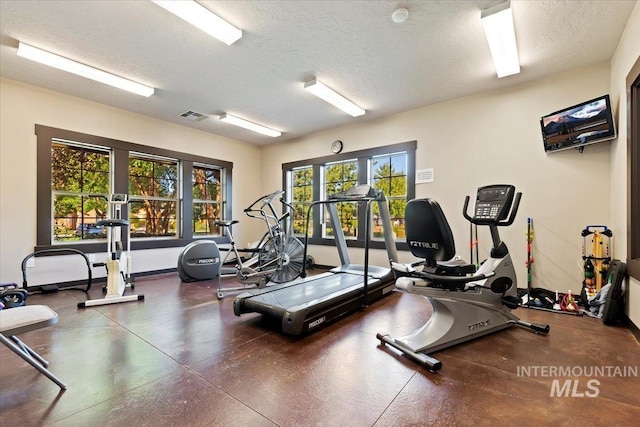 exercise room with a textured ceiling