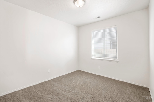 empty room featuring baseboards, carpet floors, and visible vents