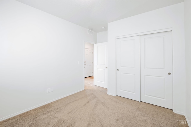 unfurnished bedroom with baseboards, carpet floors, visible vents, and a closet