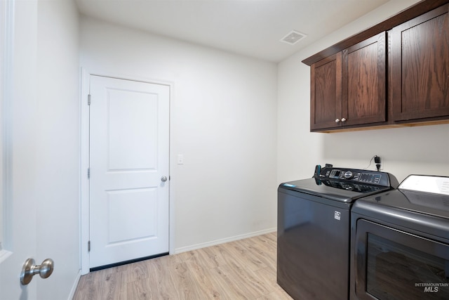 laundry room featuring visible vents, baseboards, light wood-style floors, washer and dryer, and cabinet space