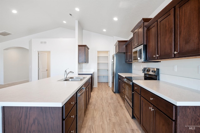 kitchen featuring light countertops, visible vents, appliances with stainless steel finishes, arched walkways, and a sink