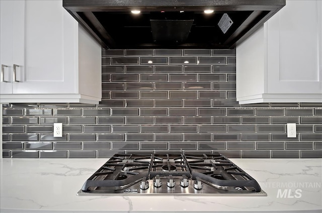 2843 E Murchison St, Meridian, ID 83642 - kitchen view of white cabinetry, stainless steel gas stovetop, and decorative backsplash
