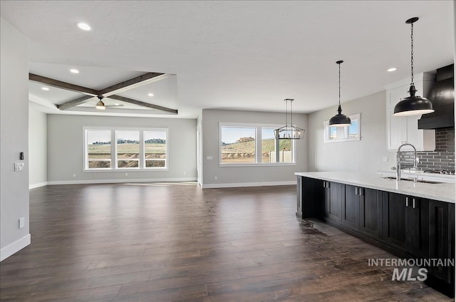 2843 E Murchison St, Meridian, ID 83642 - kitchen featuring dark wood-type flooring, a sink, dark cabinetry, open floor plan, and baseboards