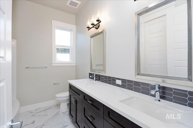 2843 E Murchison St, Meridian, ID 83642 - bathroom featuring toilet, baseboards, double vanity, marble look tile flooring, and tasteful backsplash