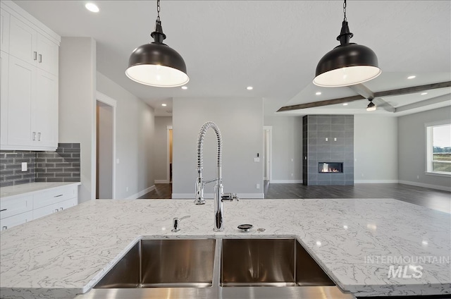 2843 E Murchison St, Meridian, ID 83642 - kitchen with a sink, light stone counters, recessed lighting, white cabinets, and coffered ceiling