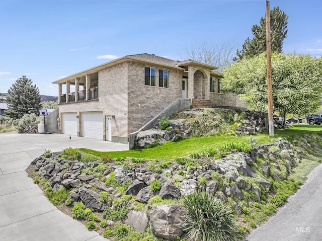816 River View Dr, Twin Falls, ID 83301 - view of front facade with concrete driveway, an attached garage, brick siding, and a balcony