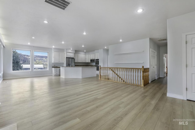 816 River View Dr, Twin Falls, ID 83301 - unfurnished living room featuring baseboards, light wood-style floors, and visible vents