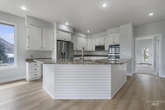 816 River View Dr, Twin Falls, ID 83301 - kitchen featuring a sink, dark stone countertops, baseboards, white cabinetry, and appliances with stainless steel finishes