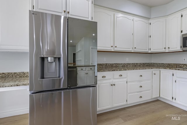 816 River View Dr, Twin Falls, ID 83301 - kitchen with light wood finished floors, dark stone counters, white cabinetry, and appliances with stainless steel finishes