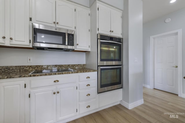 816 River View Dr, Twin Falls, ID 83301 - kitchen featuring white cabinets, stainless steel appliances, light wood finished floors, and dark stone countertops