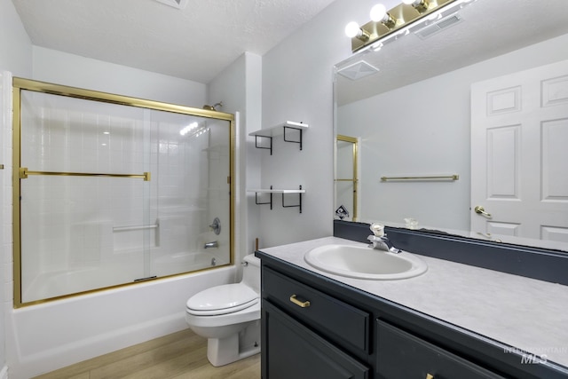 816 River View Dr, Twin Falls, ID 83301 - bathroom with wood finished floors, visible vents, toilet, vanity, and bath / shower combo with glass door