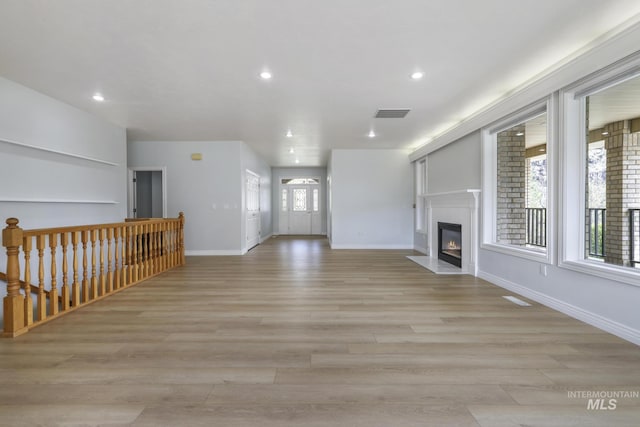 816 River View Dr, Twin Falls, ID 83301 - unfurnished living room featuring a glass covered fireplace, light wood-style flooring, visible vents, and recessed lighting