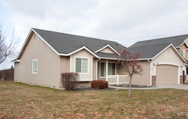 view of front of property with a front yard, covered porch, and a garage