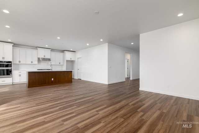 unfurnished living room with dark hardwood / wood-style floors