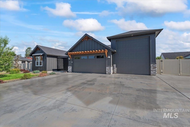 492 Applecreek St, Middleton, ID 83644 - view of front facade featuring board and batten siding, stone siding, concrete driveway, a garage, and a gate