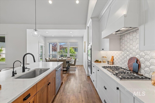 492 Applecreek St, Middleton, ID 83644 - kitchen with stainless steel appliances, brown cabinets, custom exhaust hood, dark wood-type flooring, and white cabinets