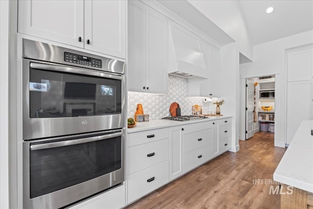 492 Applecreek St, Middleton, ID 83644 - kitchen with appliances with stainless steel finishes, light countertops, white cabinetry, decorative backsplash, and light wood-style floors
