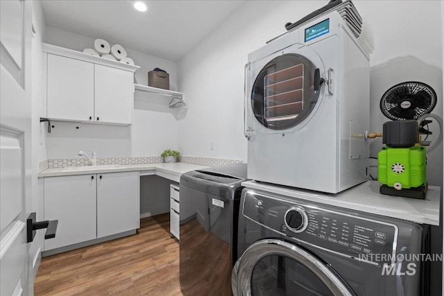 492 Applecreek St, Middleton, ID 83644 - laundry room featuring cabinet space, estacked washer and dryer, light wood-style flooring, and recessed lighting