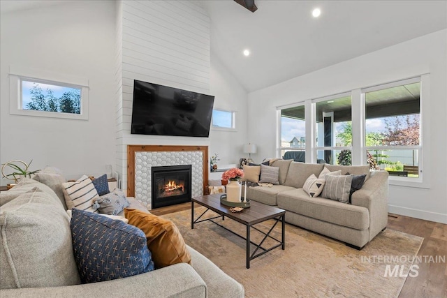 492 Applecreek St, Middleton, ID 83644 - living room with high vaulted ceiling, light wood-style floors, a tiled fireplace, and recessed lighting