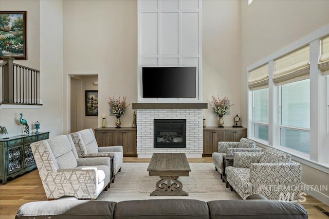 9351 W Sooty Grouse Ct, Boise, ID 83714 - living area with a high ceiling, wood finished floors, and a brick fireplace