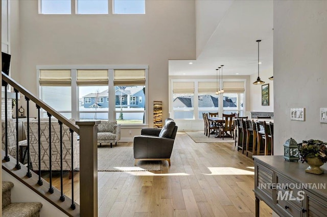 9351 W Sooty Grouse Ct, Boise, ID 83714 - living room with wood-type flooring, a towering ceiling, stairway, healthy amount of natural light, and recessed lighting