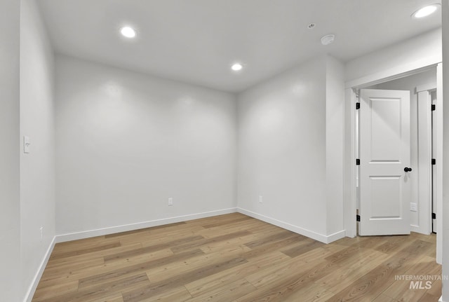 empty room featuring baseboards, light wood-style floors, and recessed lighting
