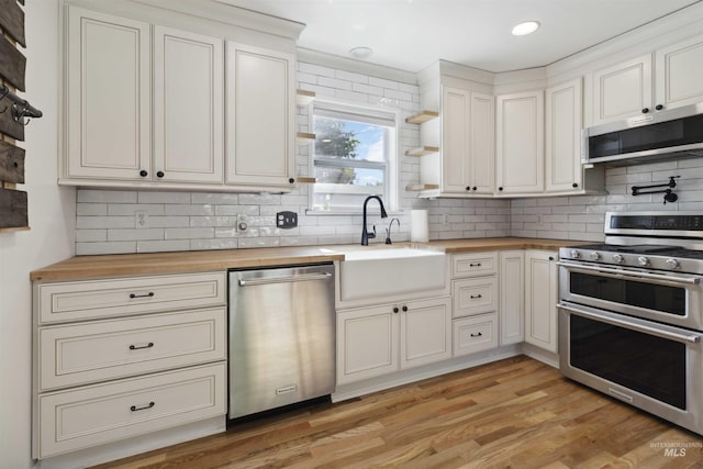 608 S Eagleson Rd, Boise, ID 83705 - kitchen with stainless steel appliances, wood counters, a sink, tasteful backsplash, and light wood-style floors