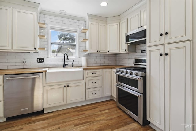 608 S Eagleson Rd, Boise, ID 83705 - kitchen featuring appliances with stainless steel finishes, butcher block counters, a sink, backsplash, and recessed lighting