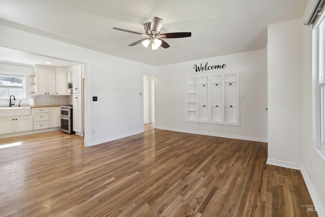 608 S Eagleson Rd, Boise, ID 83705 - unfurnished living room with a sink, wood finished floors, ceiling fan, and baseboards
