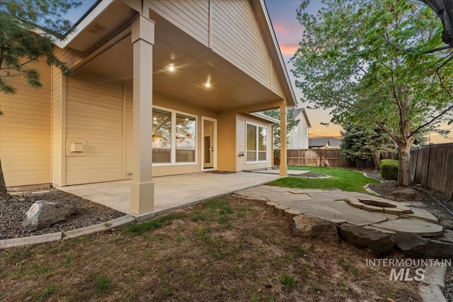 1280 W Bacall St, Meridian, ID 83646 - back of house at dusk with a fenced backyard and a patio area