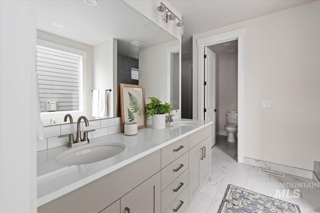 bathroom with a sink, visible vents, toilet, and marble finish floor