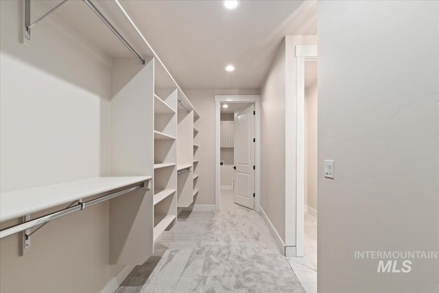 spacious closet featuring light colored carpet