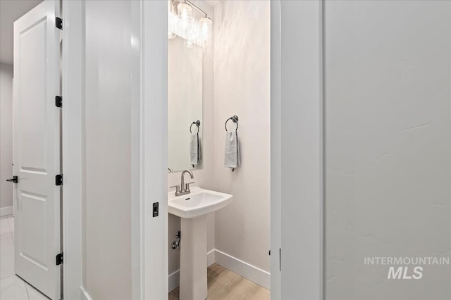 bathroom featuring a sink, baseboards, and wood finished floors