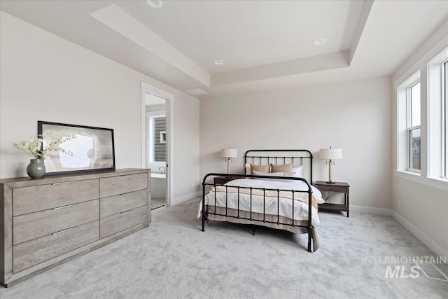 bedroom featuring a raised ceiling, carpet flooring, and baseboards