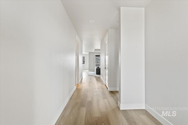 hallway with baseboards and light wood finished floors